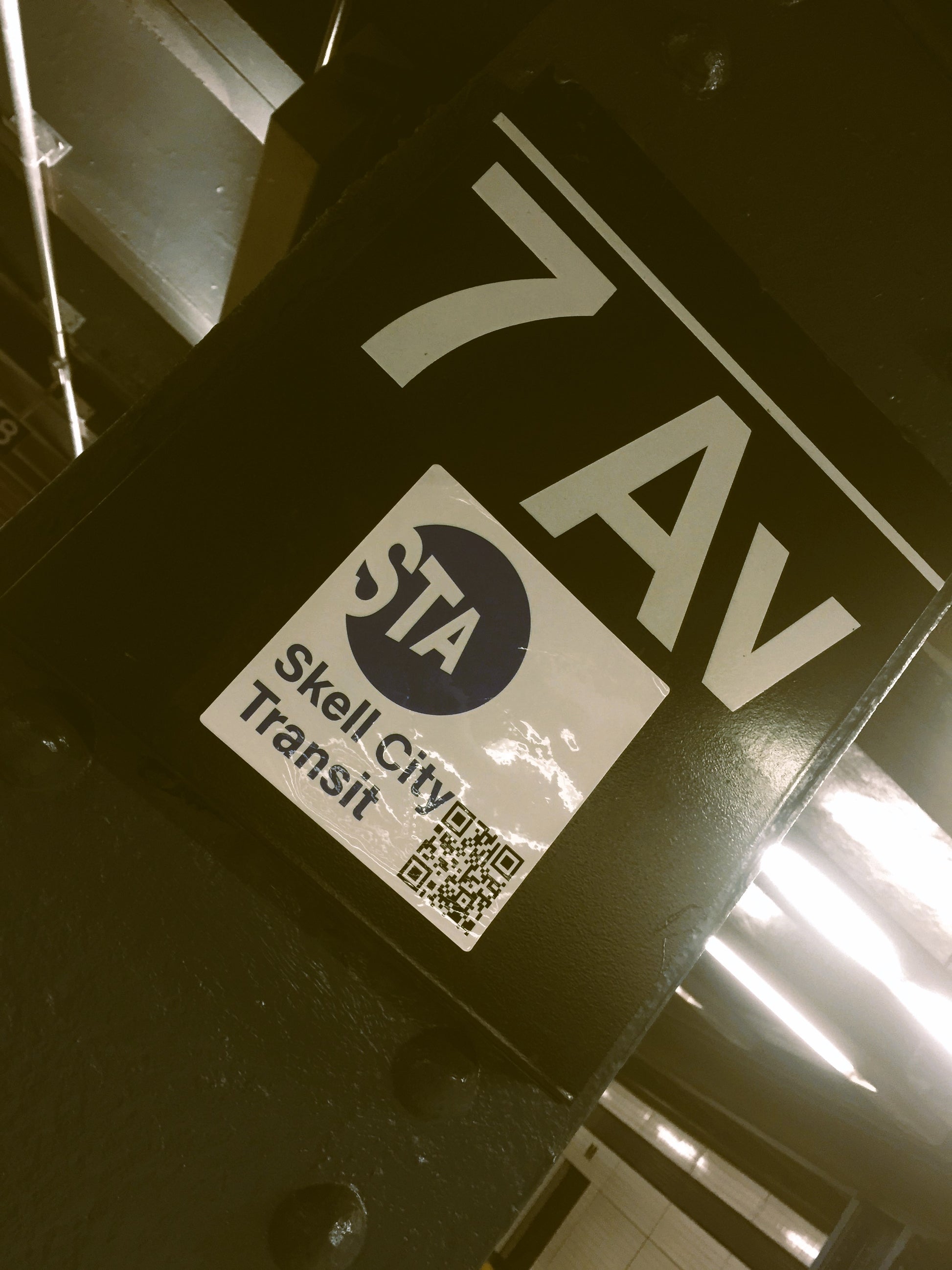 skell city station sticker posted on 7th avenue subway station platform placard