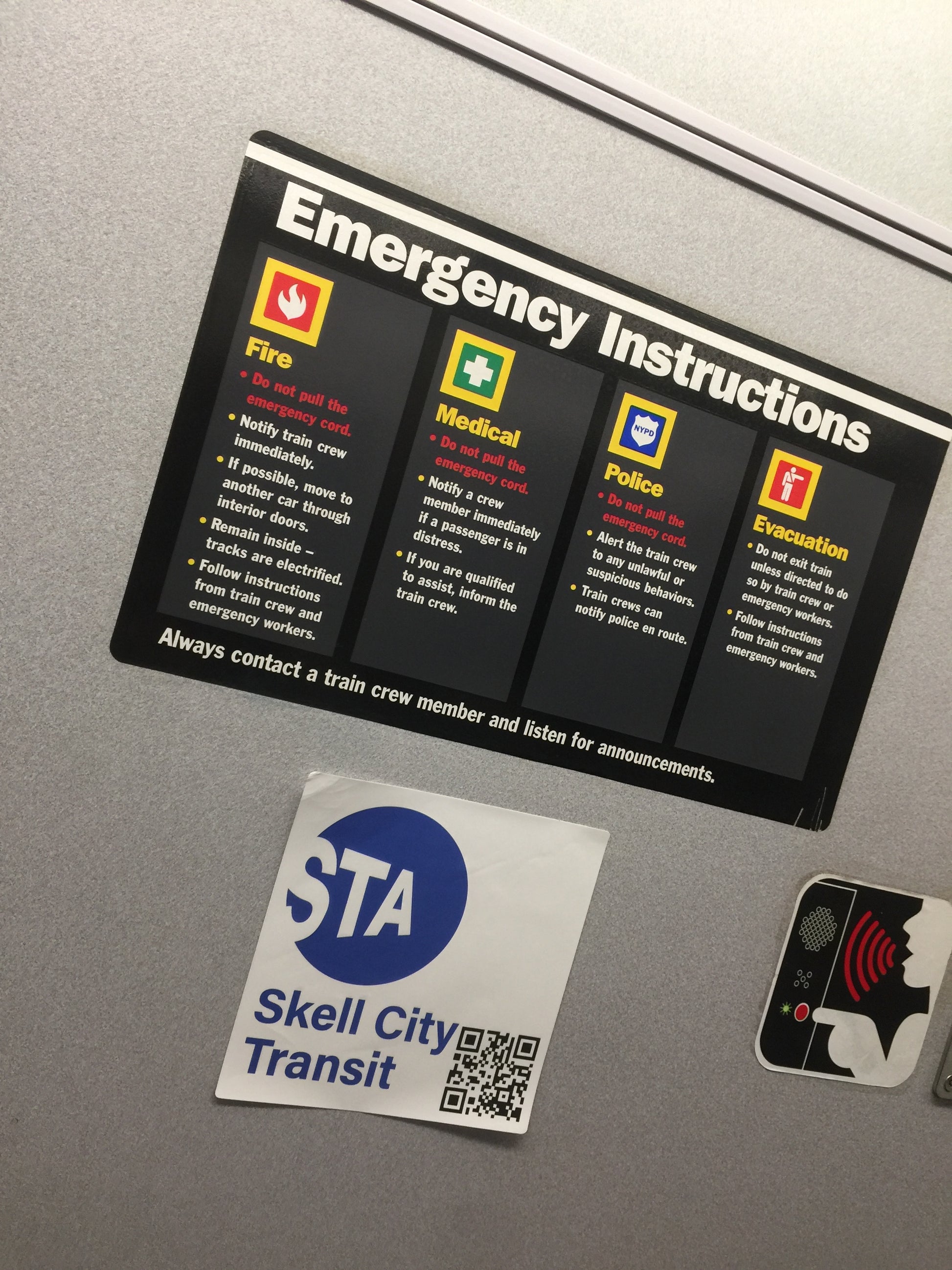 MTA station sticker next to emergency instructions sticker plaque.