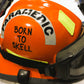Born to Skell clear sticker from skellcity, applied to the side of an orange ems bunker gear helmet.