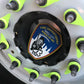 skell city EMS patch sitting inside of the spoke of an FDNY ambulance wheel. 